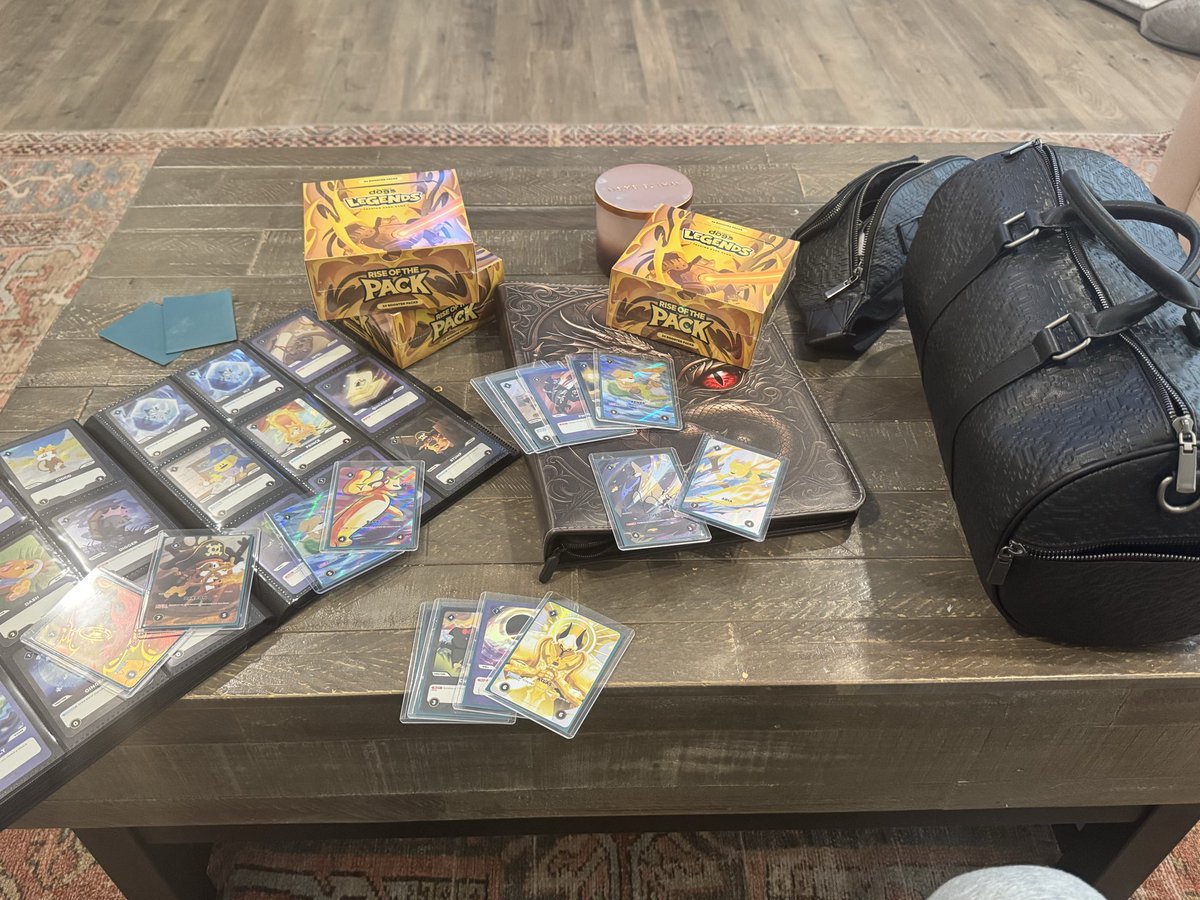 Doginal Dogs Legends TCG cards and Rise of the Pack boxes on a wooden table